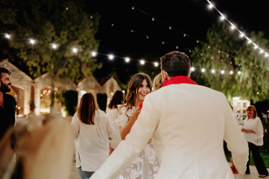 Sposi e invitati che ballano all'aperto nel parco della casina, sotto le lampadine appese fra gli alberi